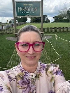 Amanda from RollCall in front of the Hobbiton Movie Set sign